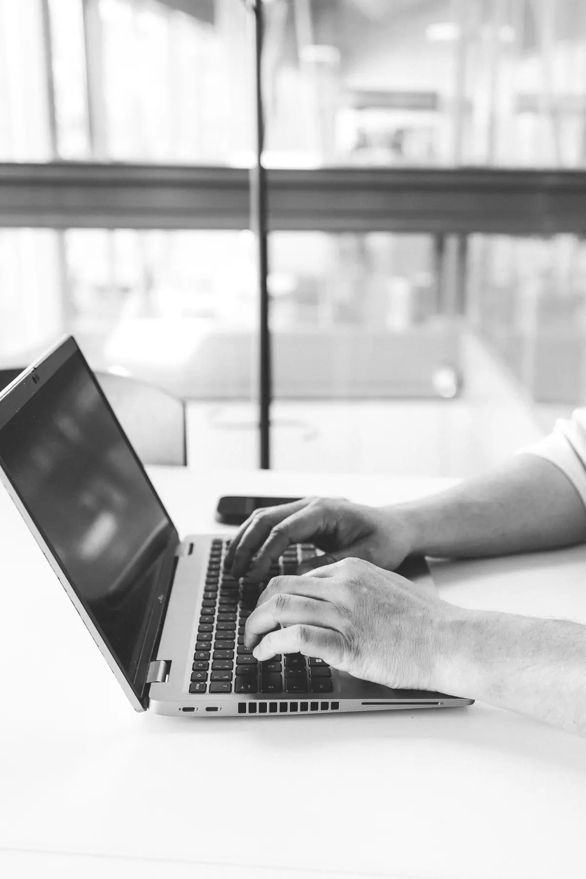 Mains sur le clavier d'un ordinateur portable
