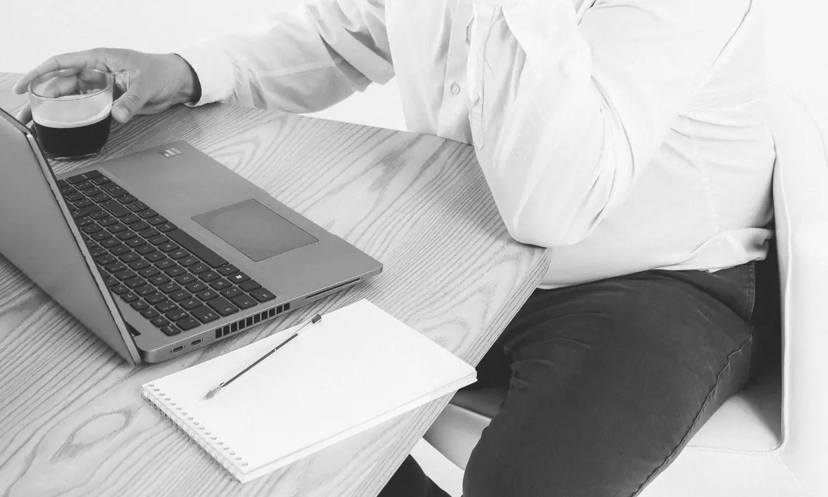 Ordinateur portable, carnet et café : le suivi d'un projet informatique