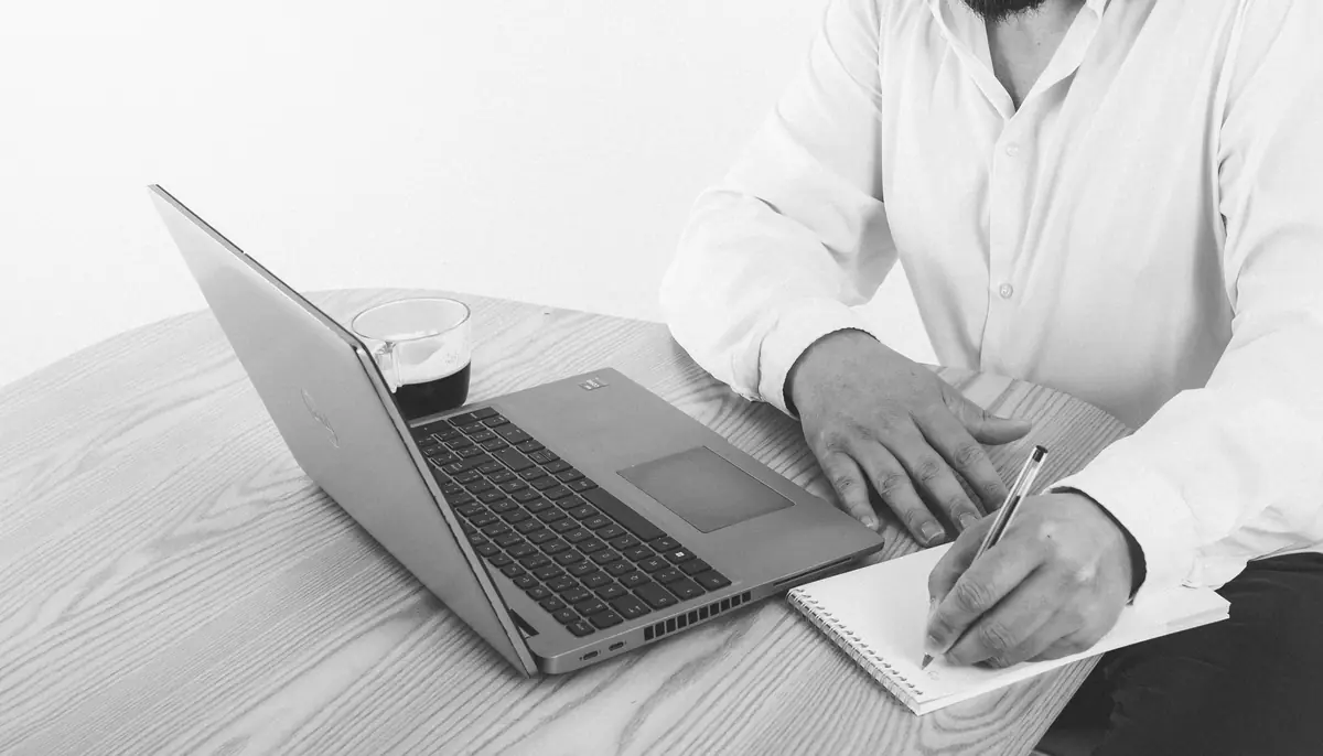 Prise de notes à côté d'un ordinateur pour construire un plan d'actions
